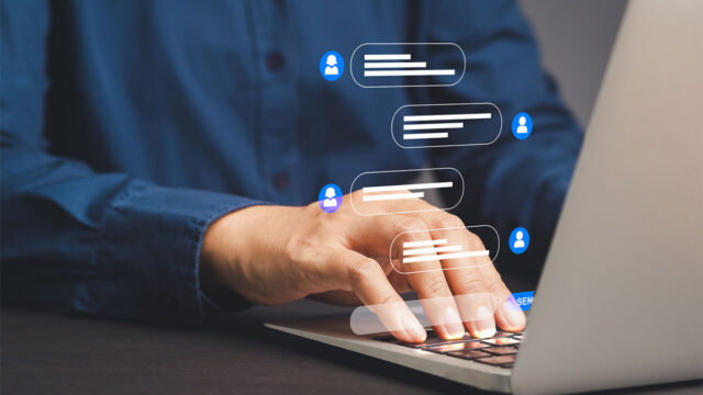 A person typing at a laptop with a generated graphic of a two-way online chat